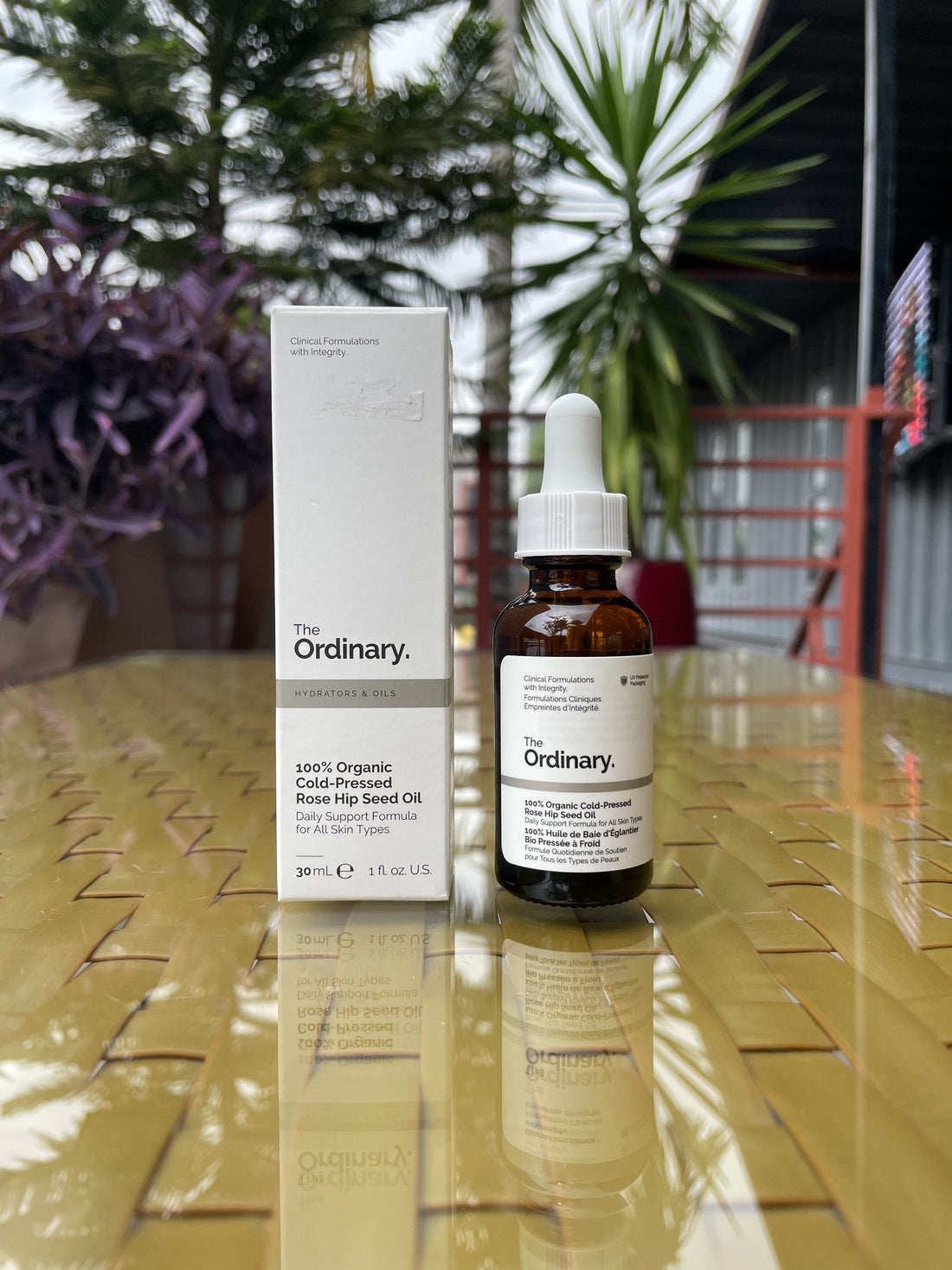 The Ordinary 100% Organic Cold-Pressed Rosehip Seed Oil bottle with rose petals and natural ingredients for skincare