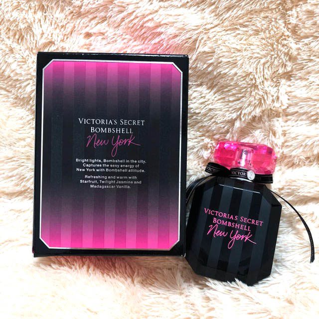 Victoria's Secret Bombshell New York Eau de Parfum bottle with sleek black dress and NYC skyline background